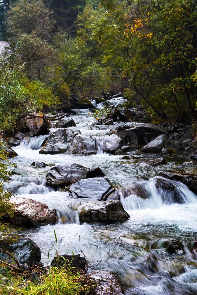 Mountain stream flowing over rocks photo