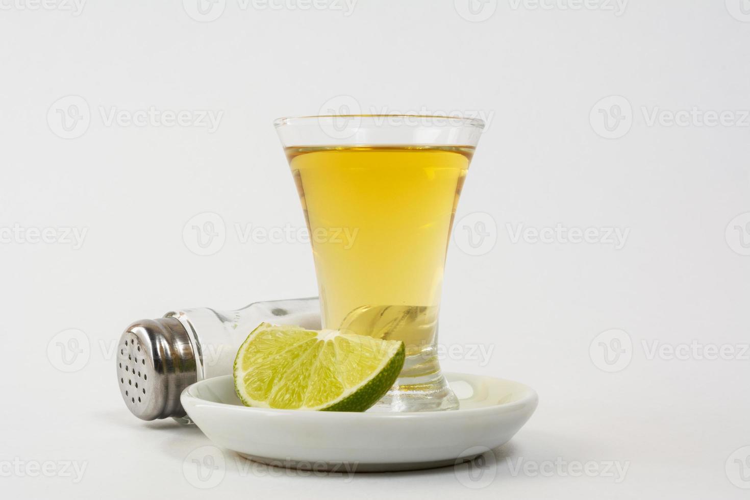 Gold tequila shot on the white background photo