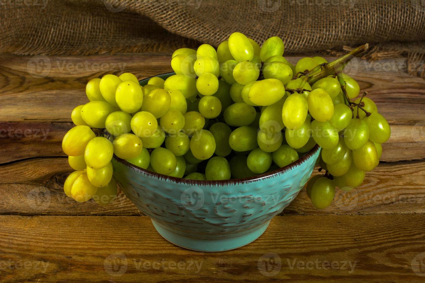 uvas blancas sobre fondo de madera oscura foto