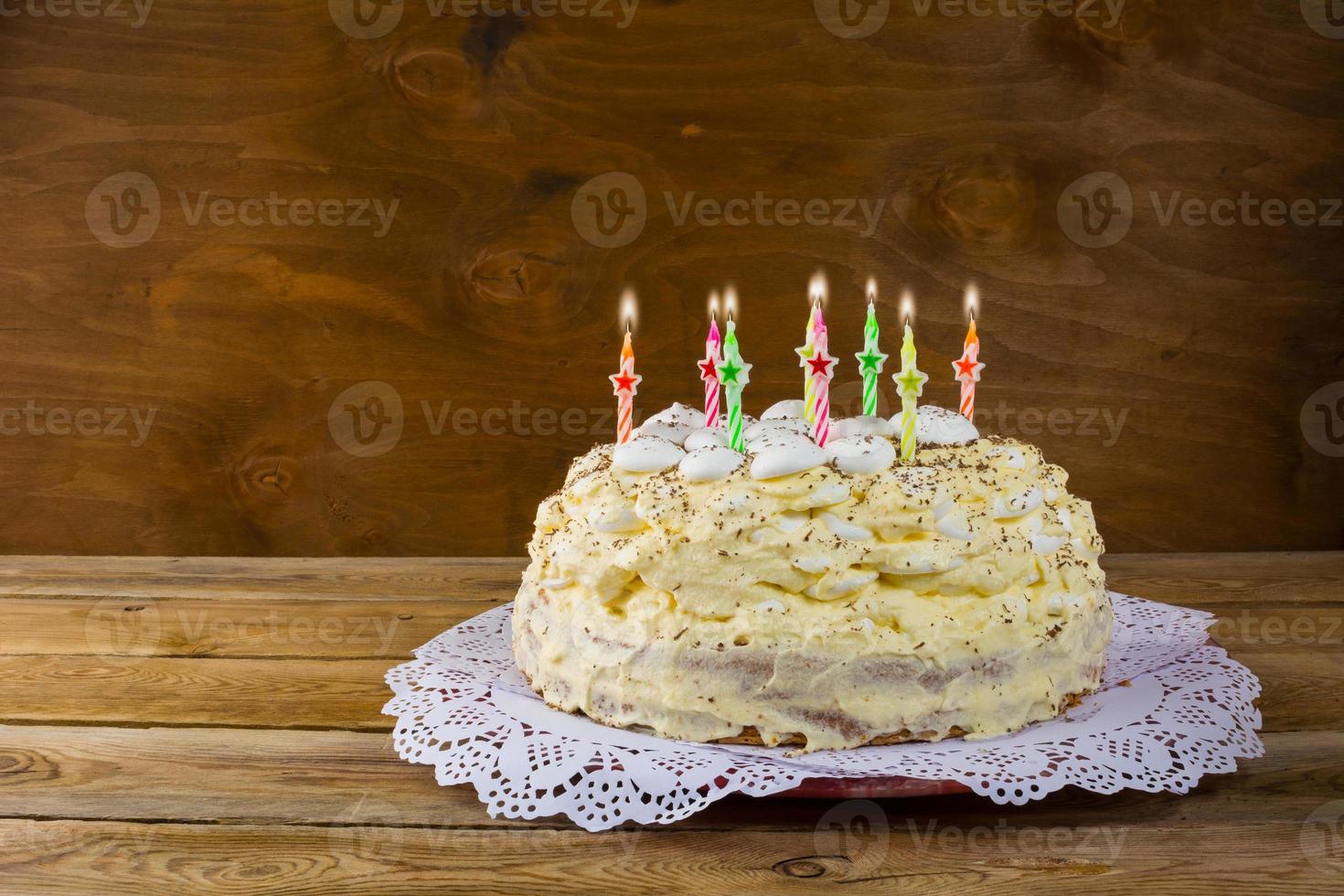 Birthday meringue cake with burning candles photo