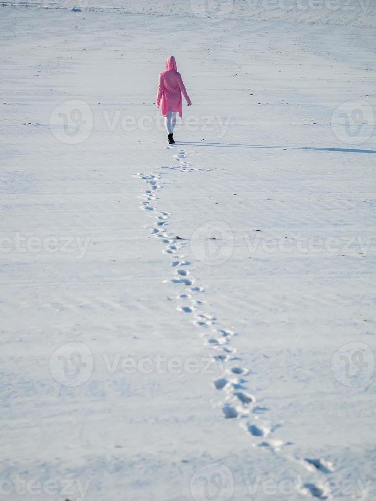 chica se va dejando huellas en la nieve foto