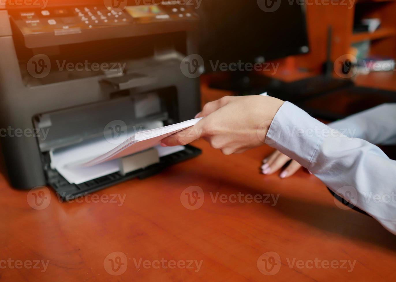 la mano humana está recargando el papel en la bandeja de la impresora foto