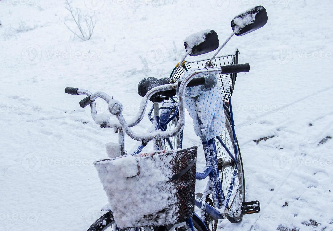 las bicicletas cubiertas de nieve están estacionadas foto