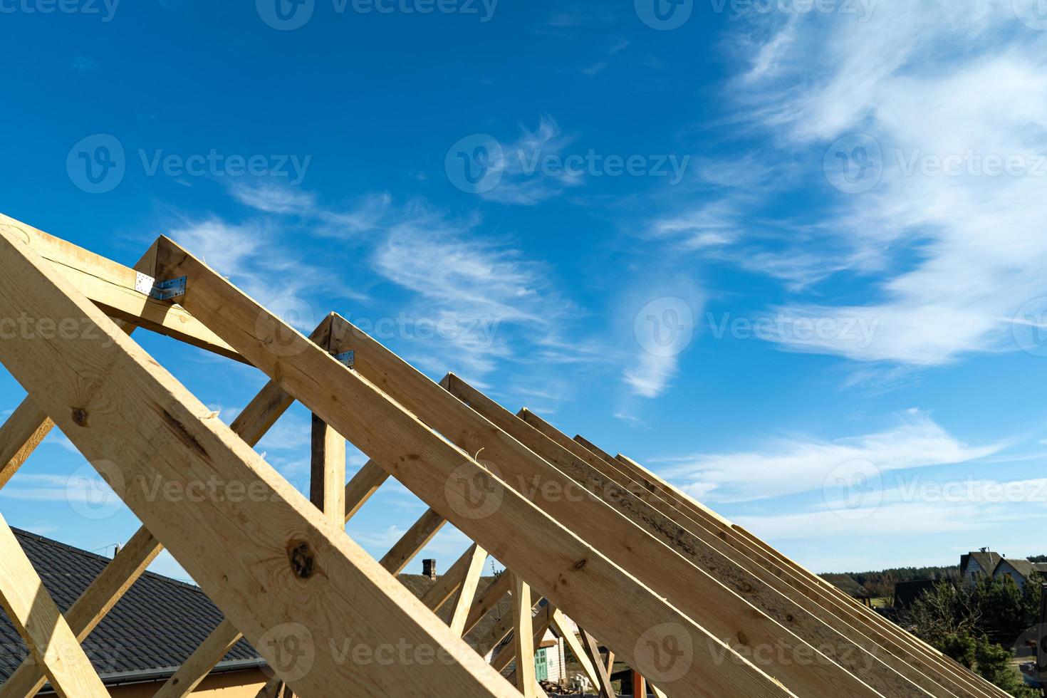 Roof trusses not covered with ceramic tile on a detached house under construction, visible roof elements, battens, counter battens, rafters. Industrial roof system with wooden timber photo