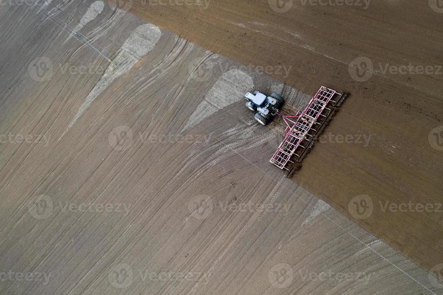 Tractor cultivating field at spring,aerial view photo