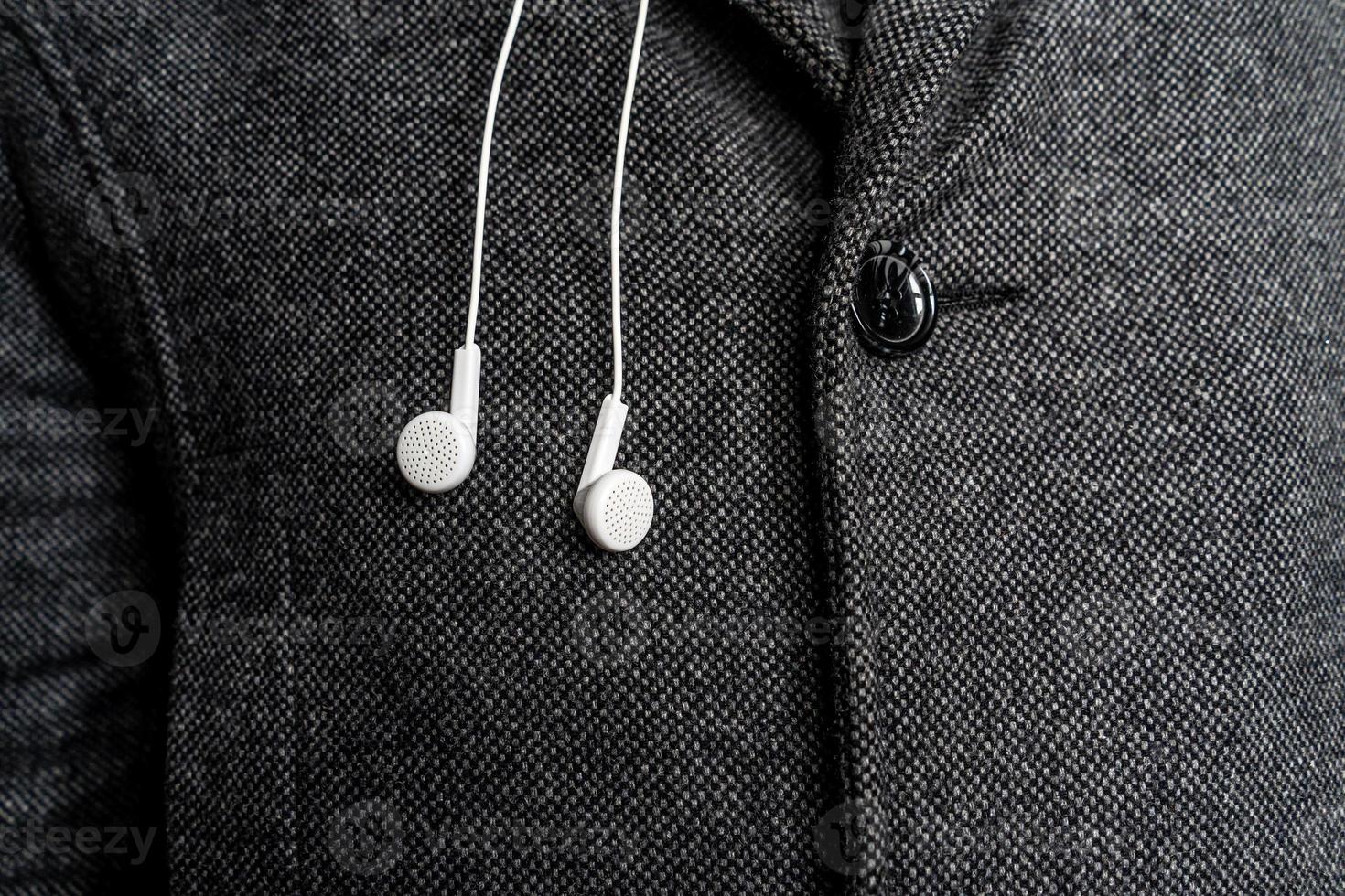 white headphones on the background of a man's coat. photo