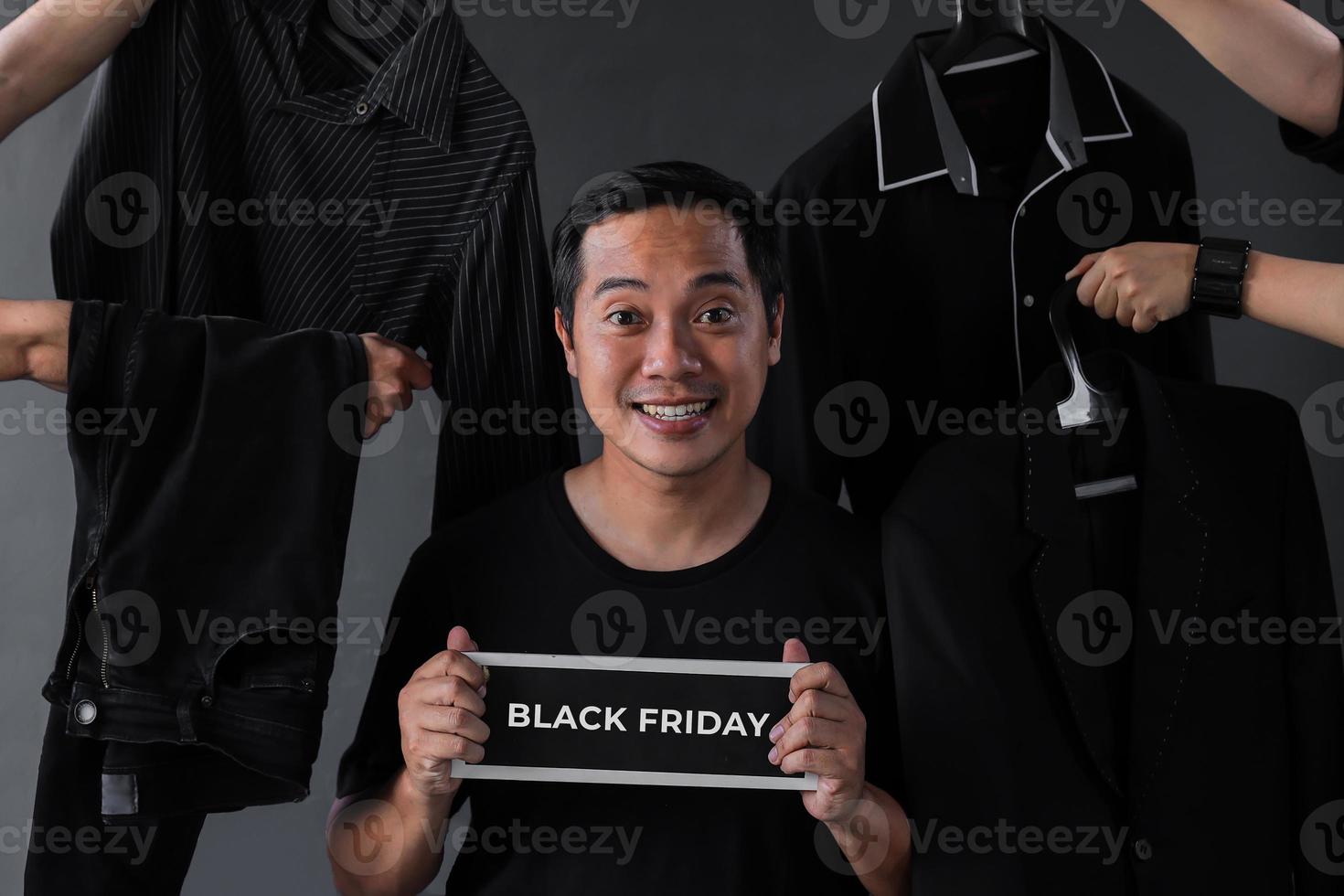 promoción de venta de viernes negro con modelo de hombre adicto a las compras rodeado de ropa negra y accesorios de hombre foto