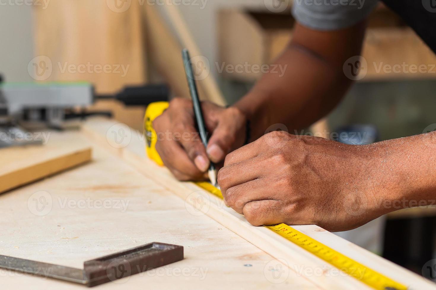 Hand of carpenter working on workshop table using measuring tools photo