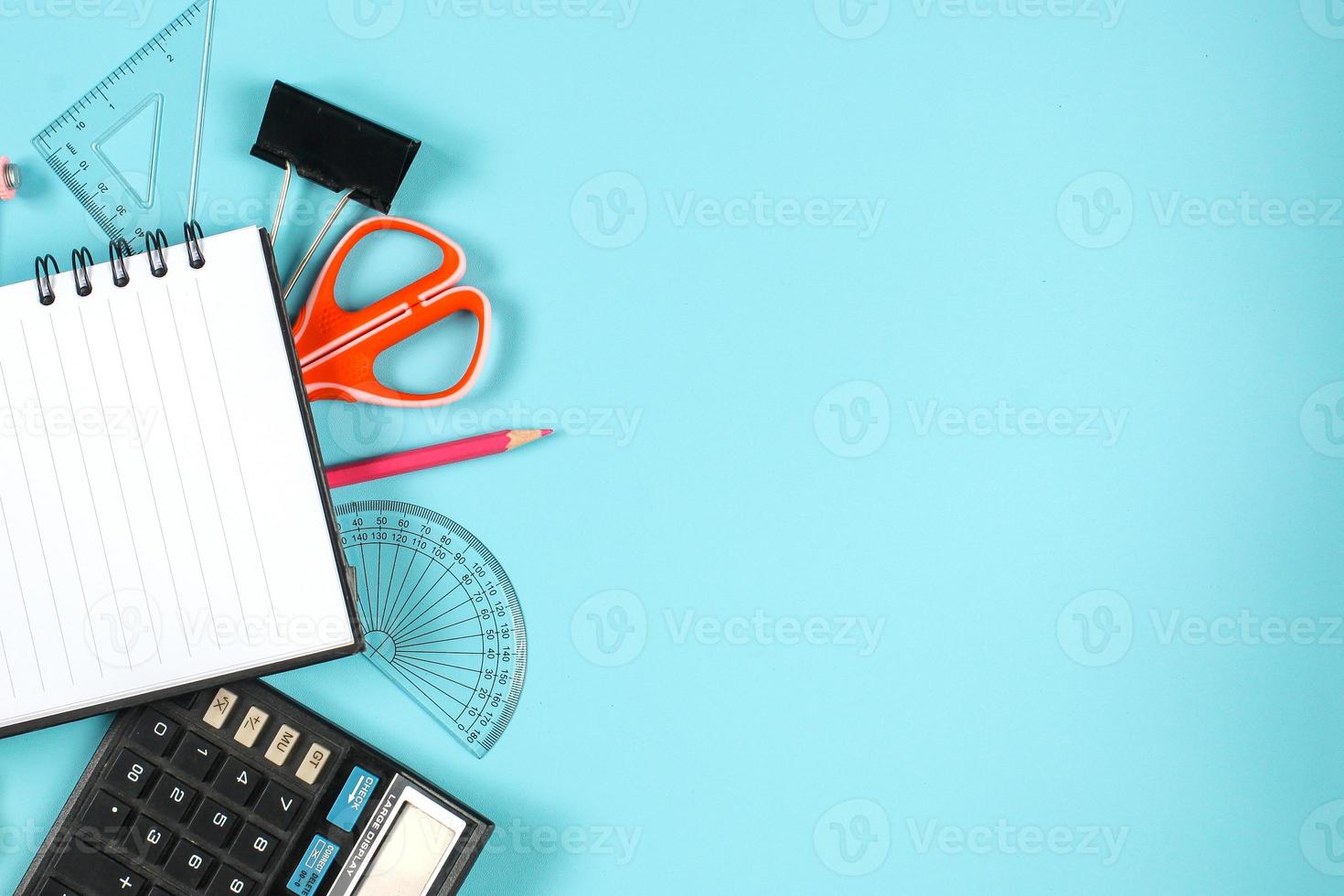 Flat lay of stationery and mathematical tools on blue background with copy space photo