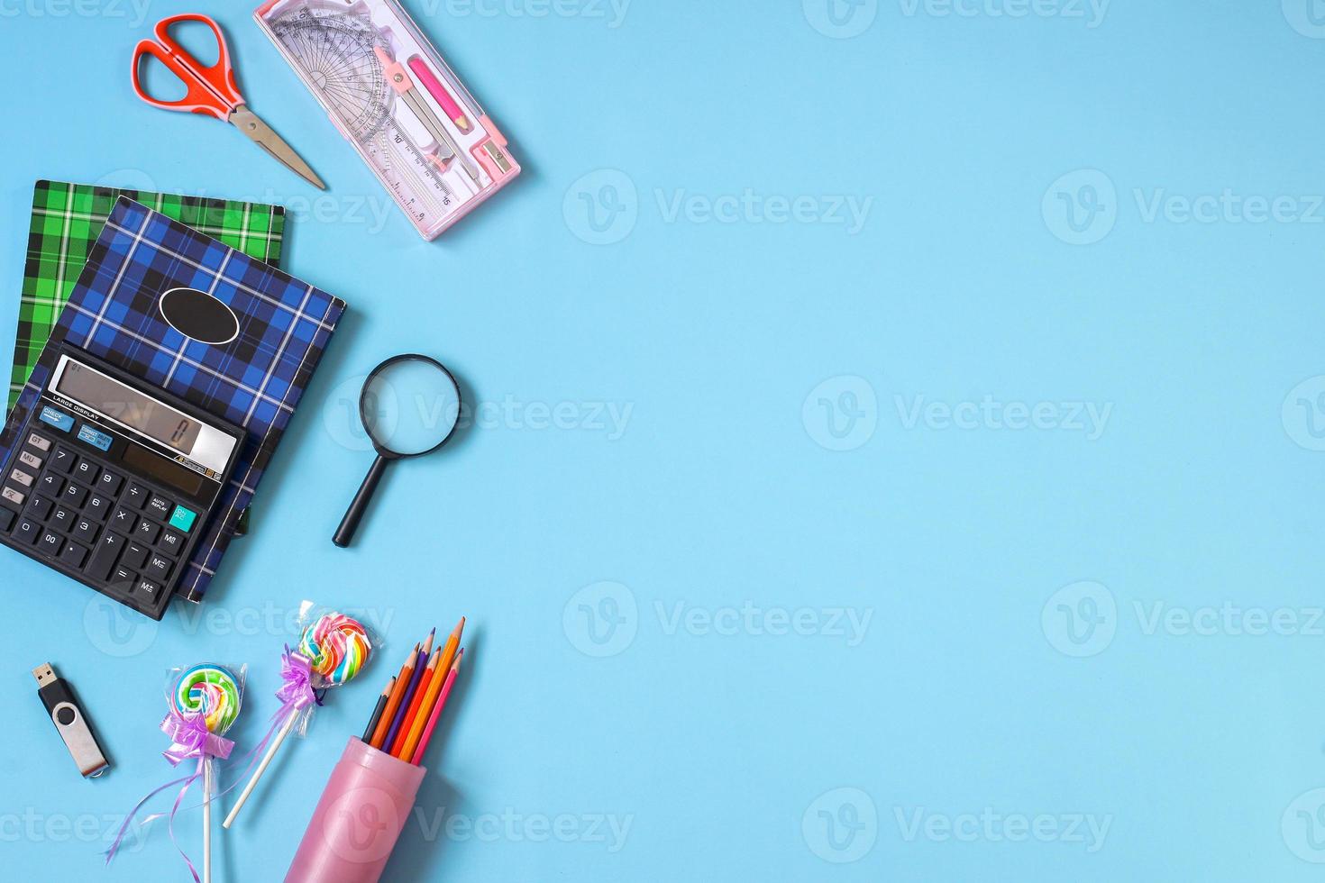 Creative flat lay school supplies on blue background for back to school concept photo