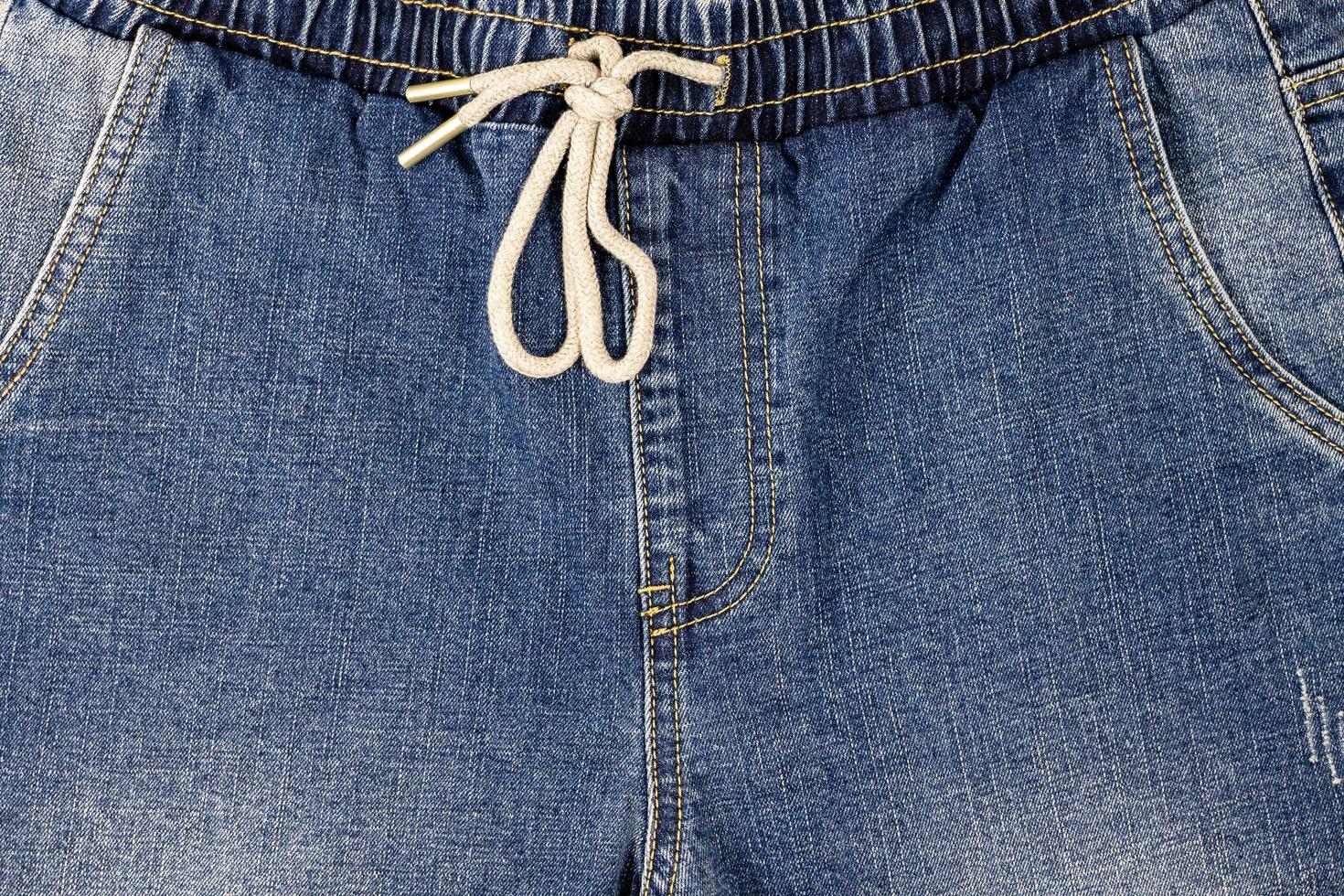 la textura de fondo en la parte delantera de los jeans tiene un cordón en la cintura y un bolsillo delantero foto