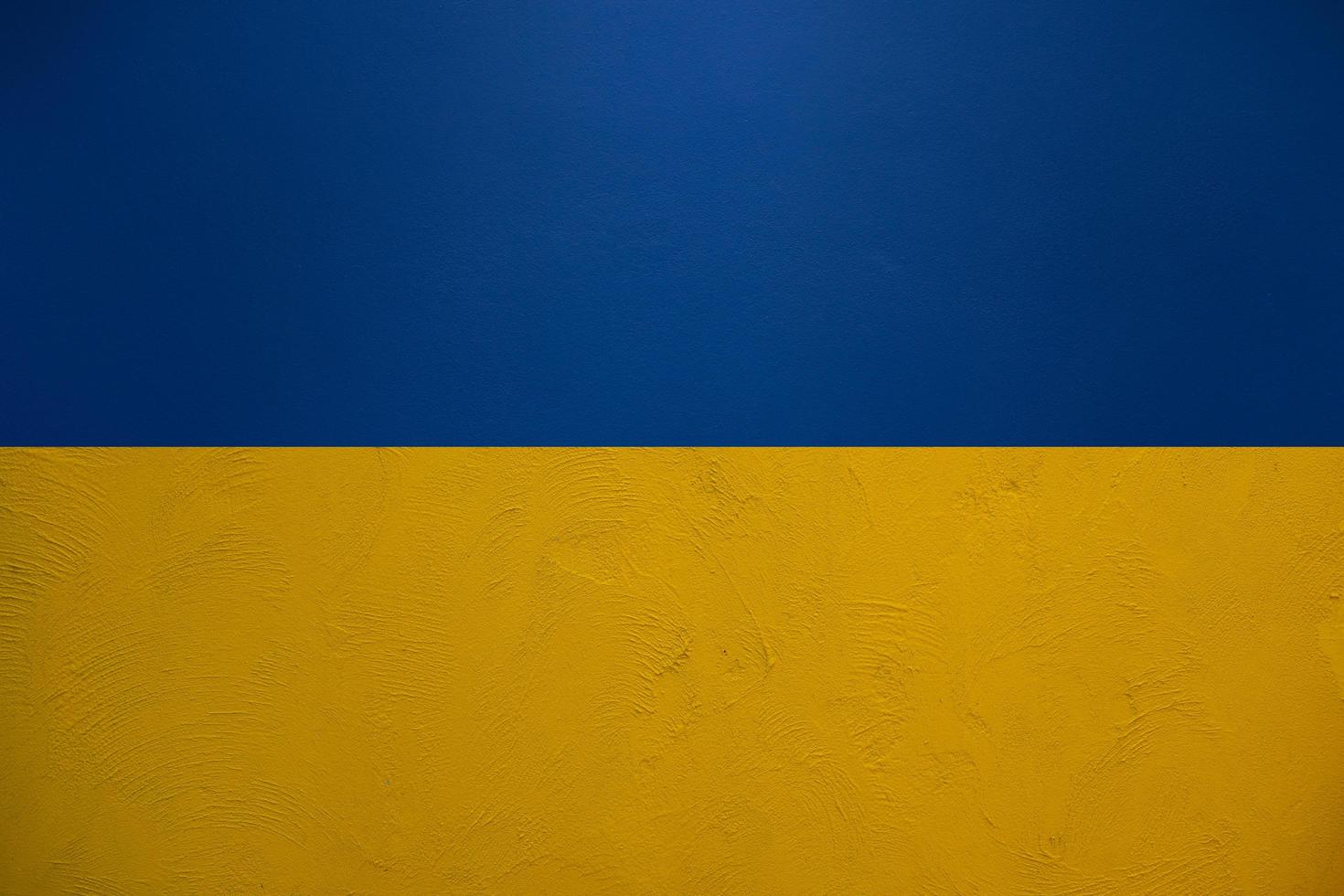 Ukraine flag background in blue and yellow from plaster wall texture pattern photo