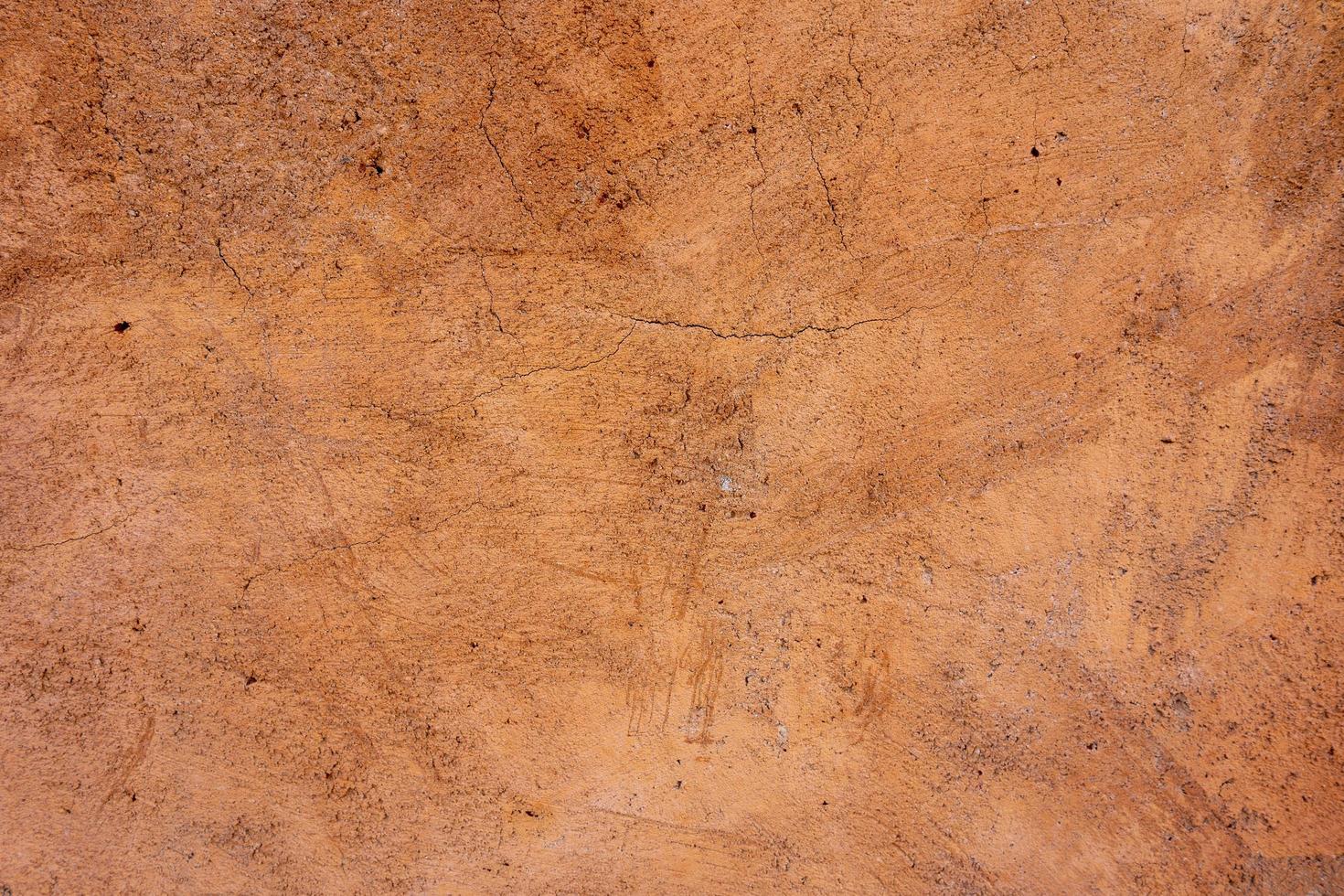 Beige brown exterior plaster wall texture background with scratch and crack pattern photo