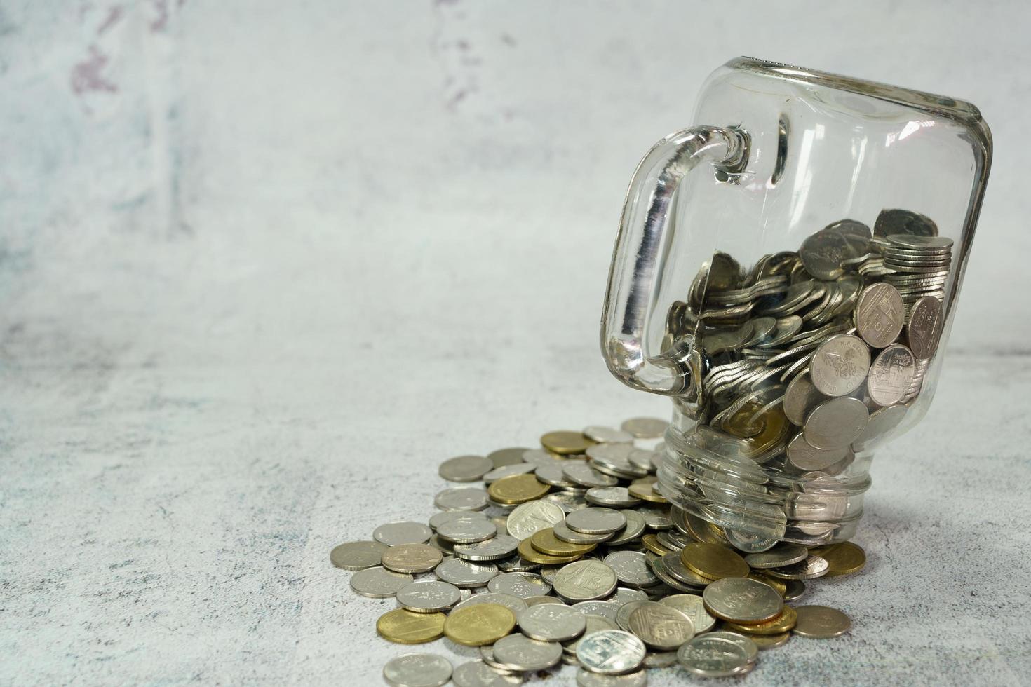 A glass jar with coins upside down to the floor. photo