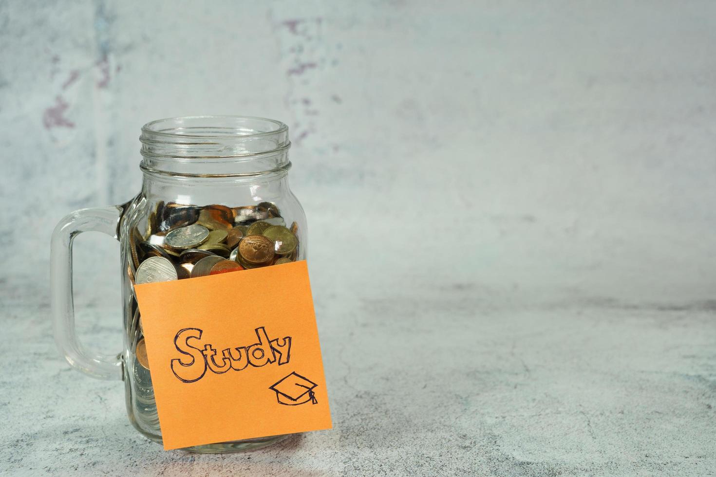 concept to save money for study,notepaper on money box,glass bottle with coin photo