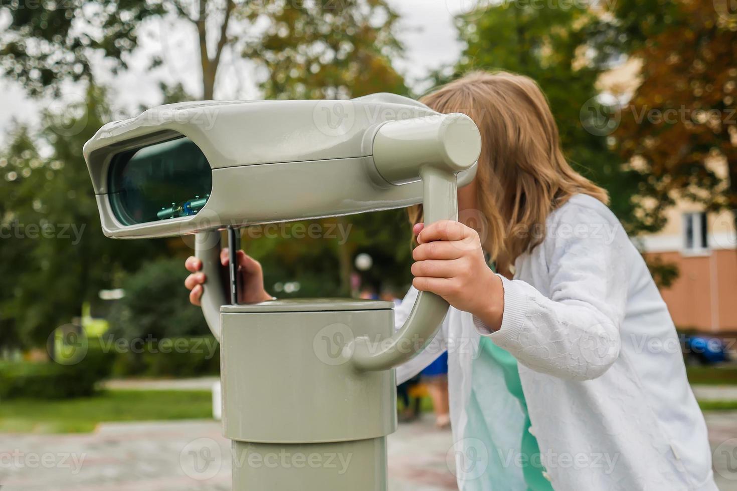 girl looking through binoculars photo