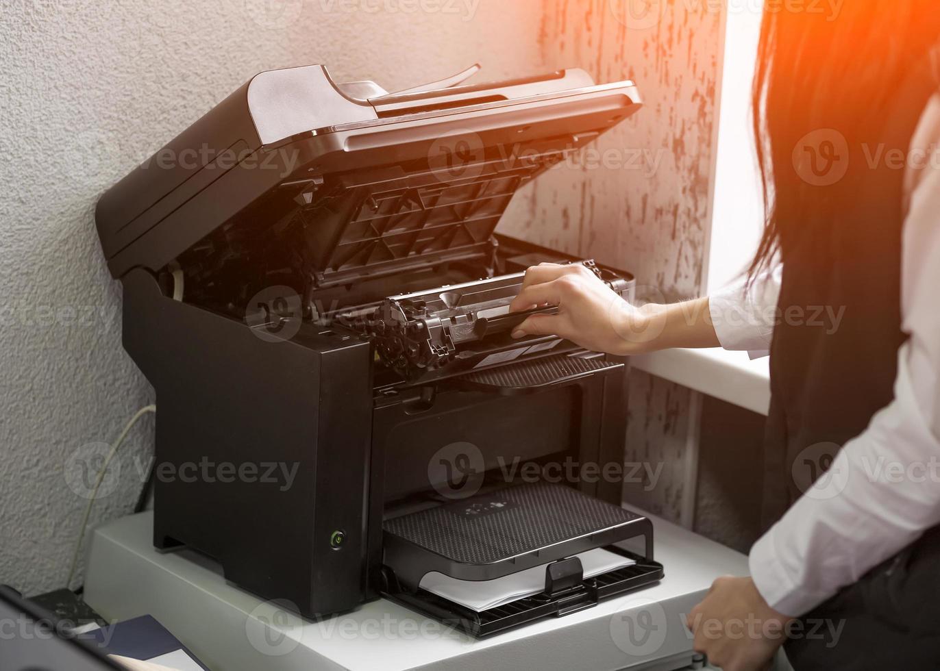 office worker change the cartridge in a laser printer photo