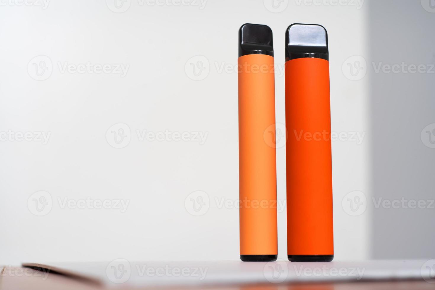 two disposable e-cigarettes on a yellow background. The concept of modern smoking, vaping and nicotine. Top view photo