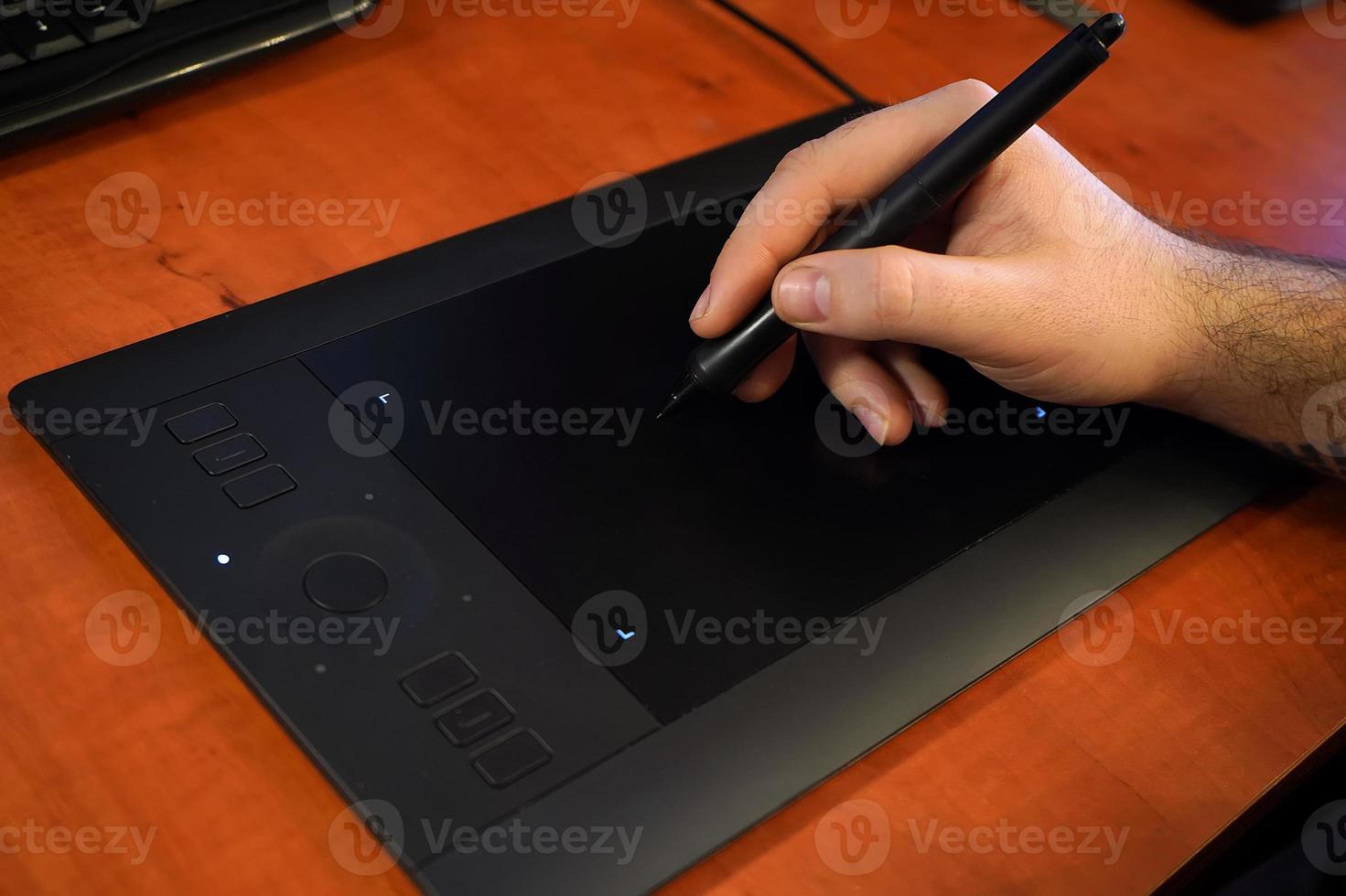 the designer draws on a graphic tablet in close-up photo