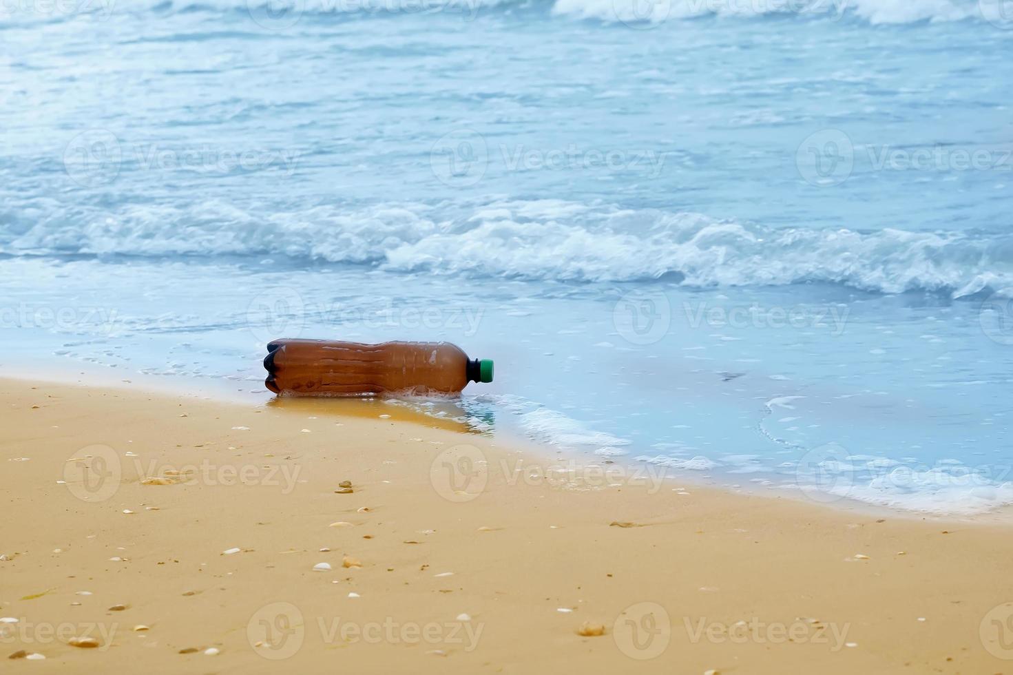 plastic bottle on the beach, sea pollution photo