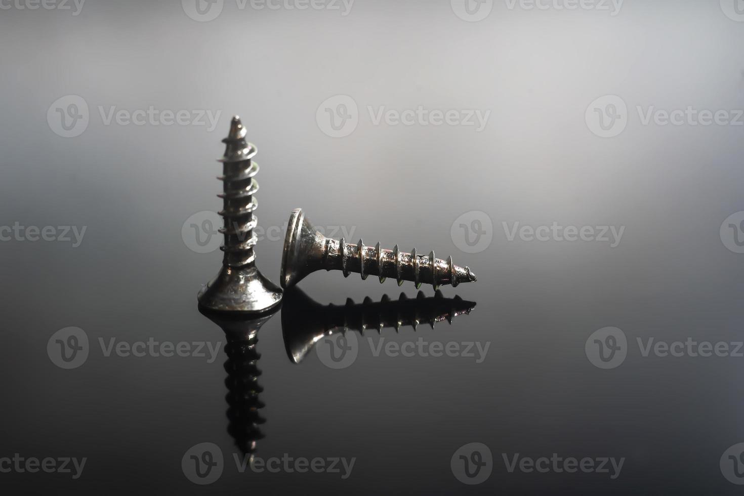 screws close up on a black background macro photo. photo
