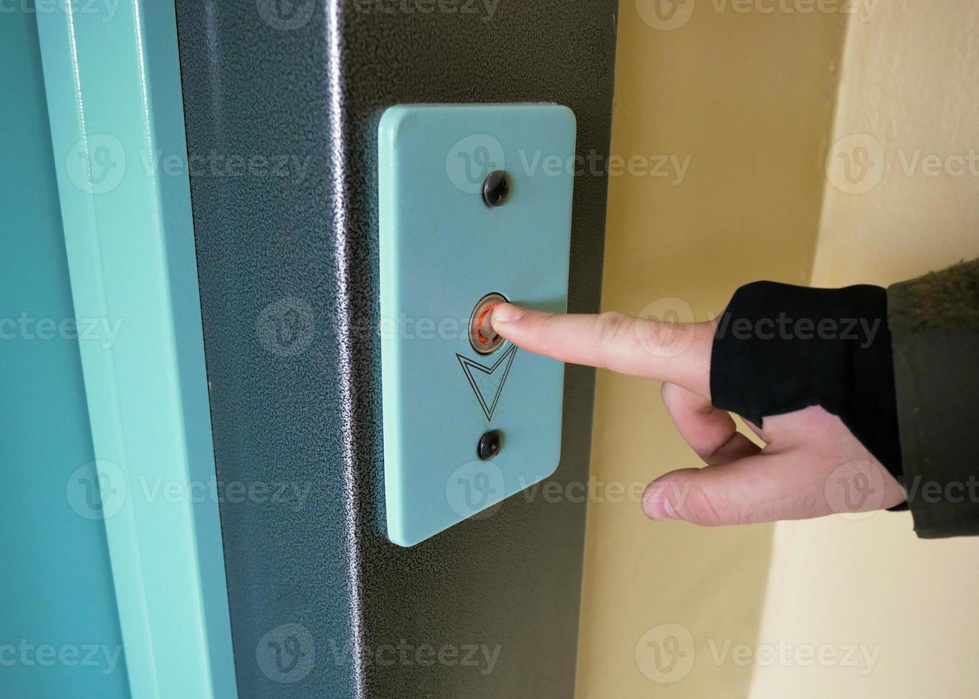 finger presses the Elevator call button close up photo