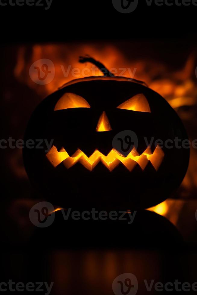 scary pumpkin for Halloween celebration on the background of flames. photo