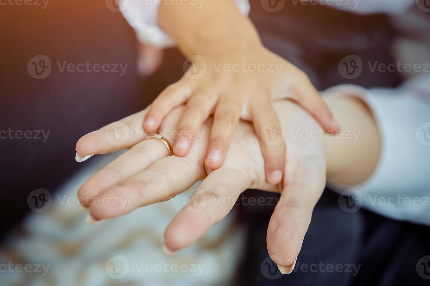 daughters hand in moms hand close up photo