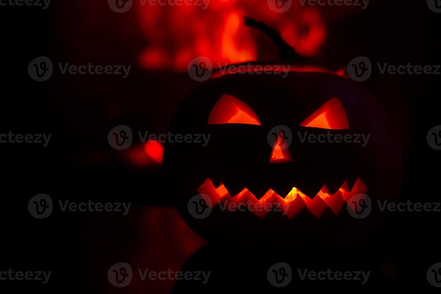 scary pumpkin for Halloween celebration on the background of flames. photo