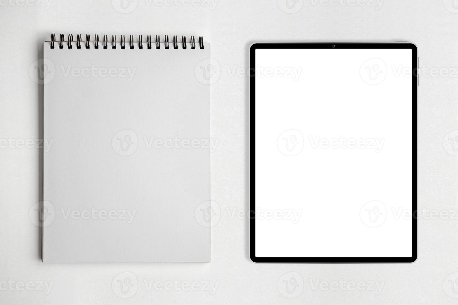 Blank paper notepad and tablet on white table background. photo