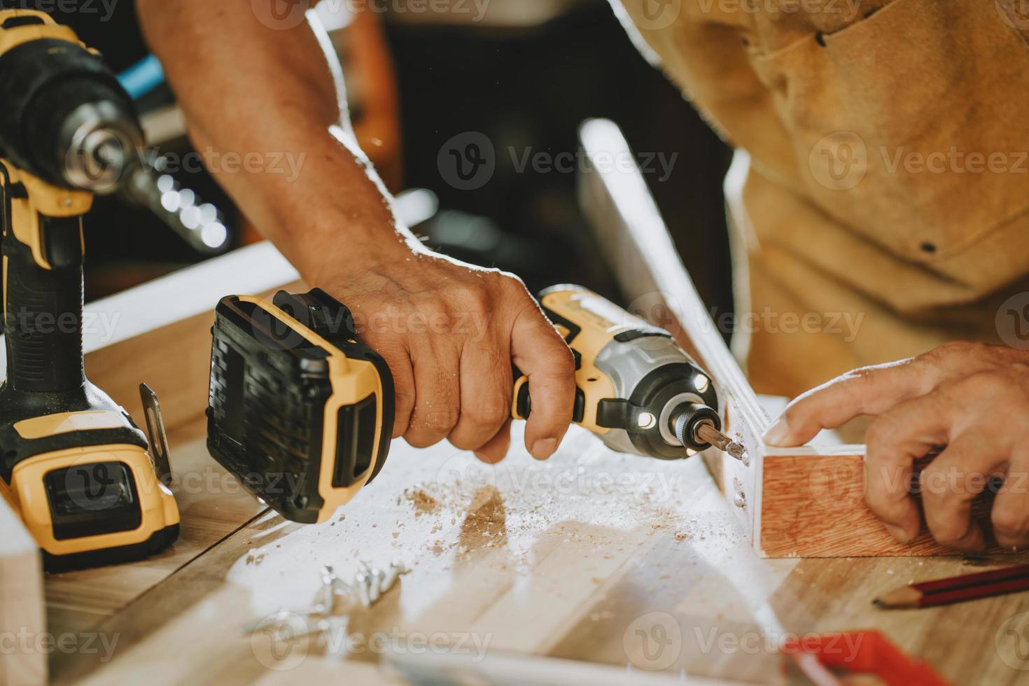 Carpenter use Cordless Drill Drive the screw on wooden ,DIY maker and woodworking concept. selective focus photo