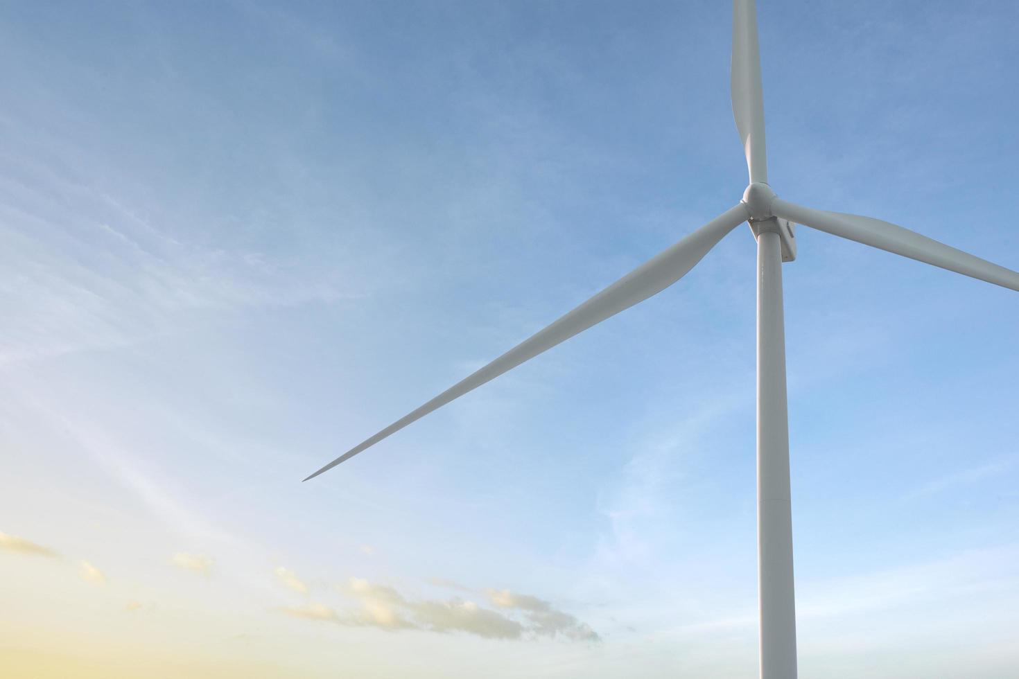 Close-up wind turbine in rotation to generate electricity energy on outdoor with  blue sky background, Conservation and sustainable energy concept. photo