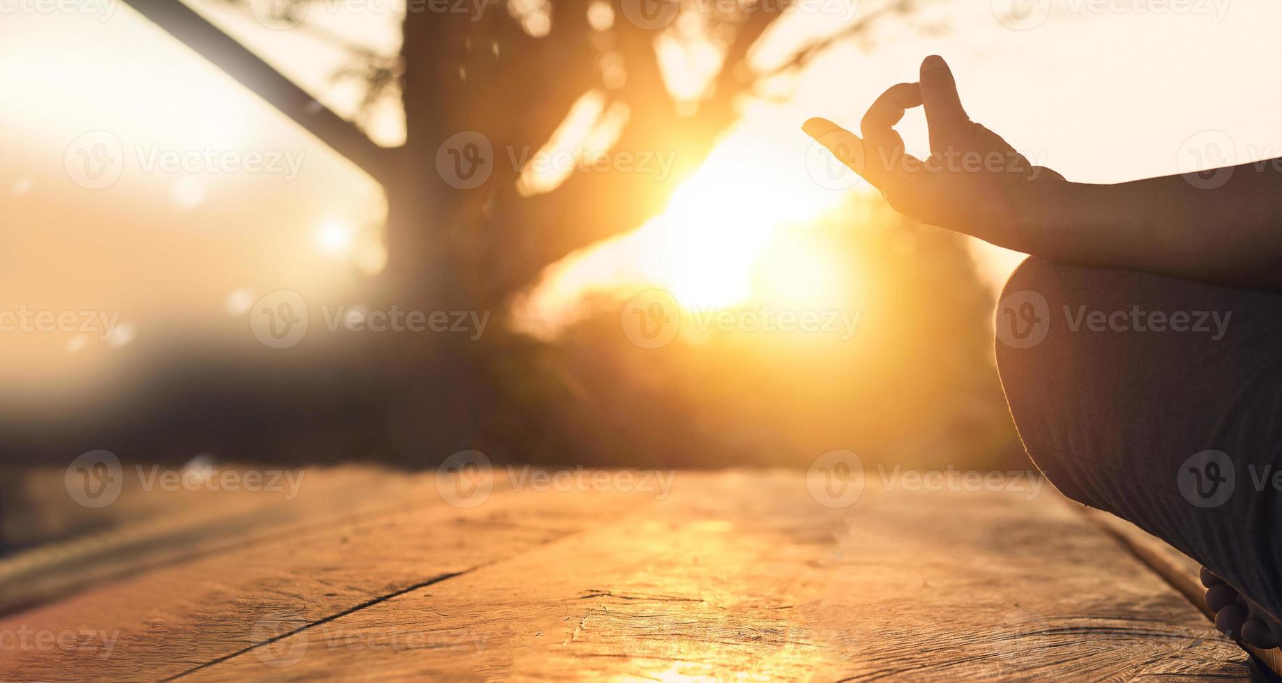 Hand of woman practicing meditation yoga on the nature at sunset photo