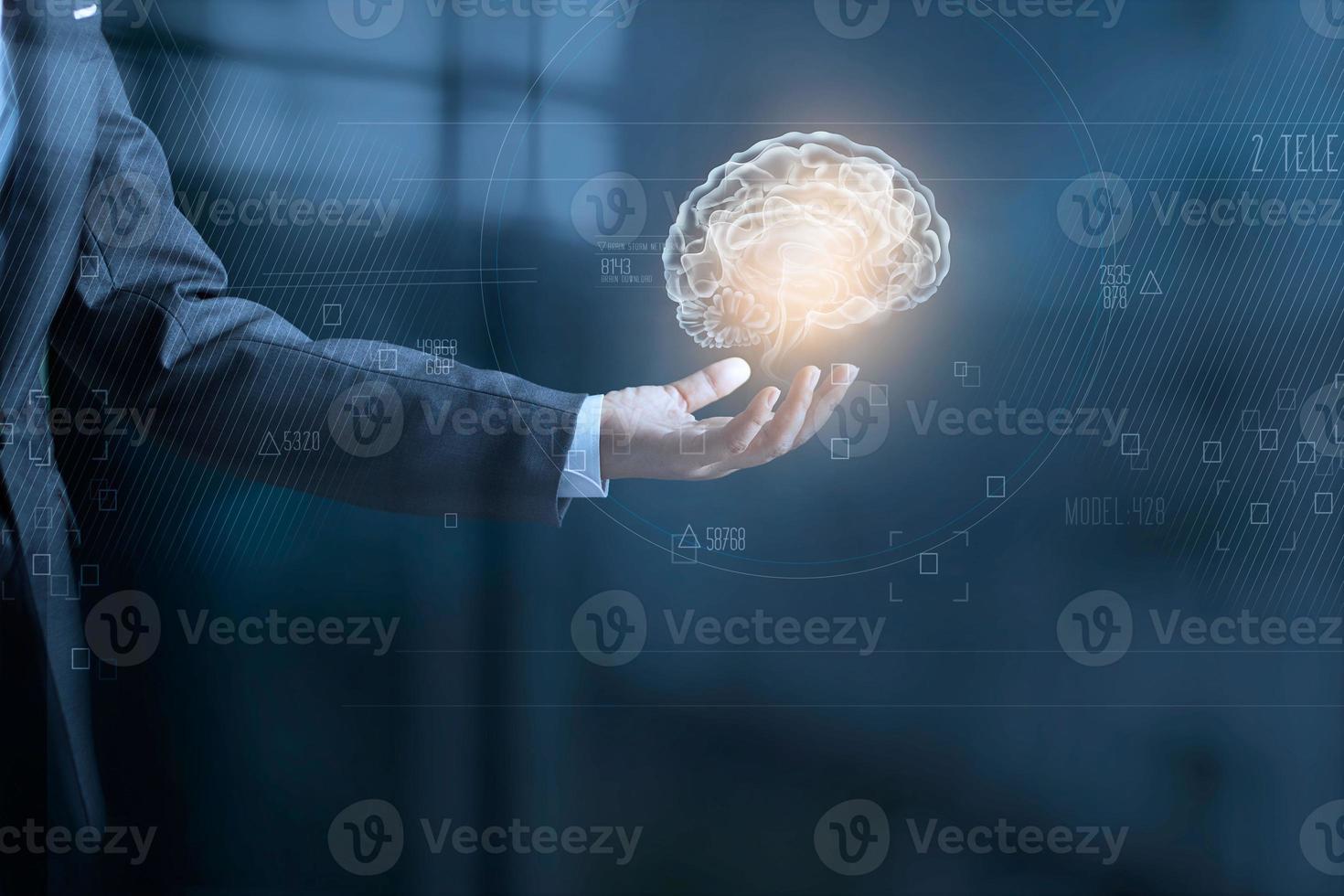 Businessman holding digital human brain and icon graphic in hand on dark blue background photo