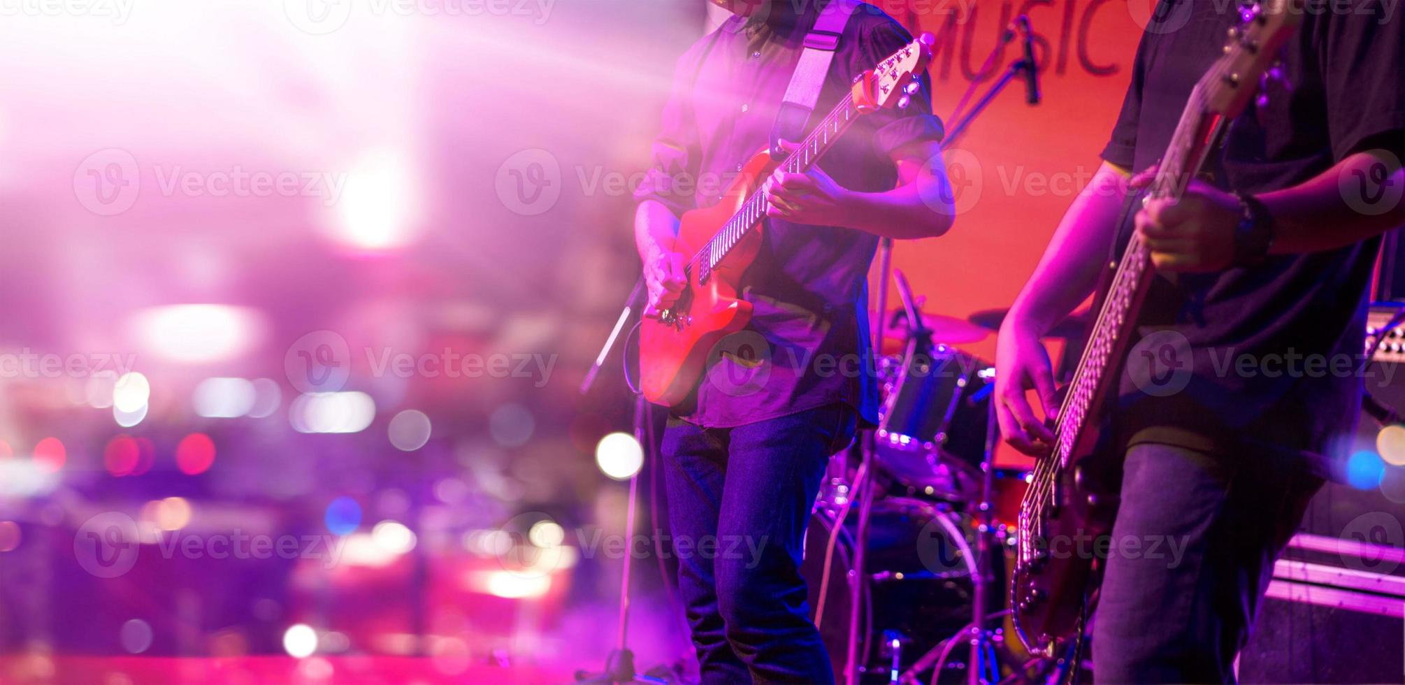 guitarrista e iluminación colorida en un escenario, enfoque suave foto