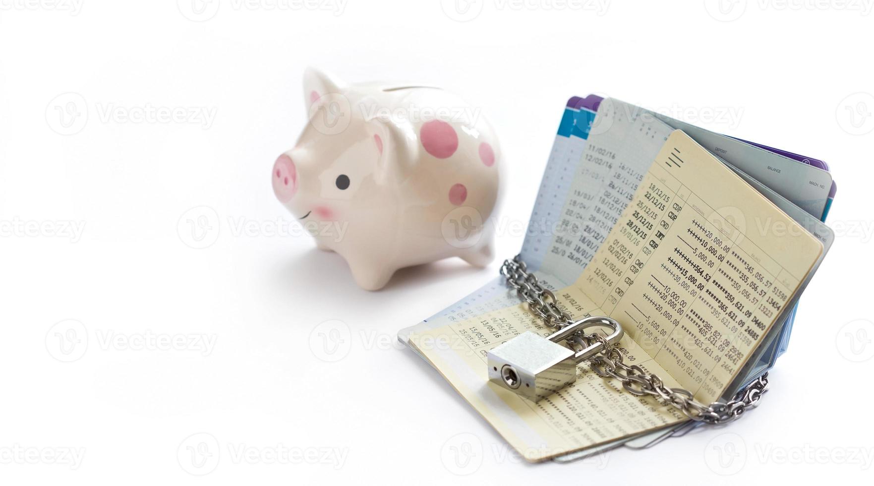 account passbooks were locked by chain and key with piggy bank on white background, saving and financial concept photo