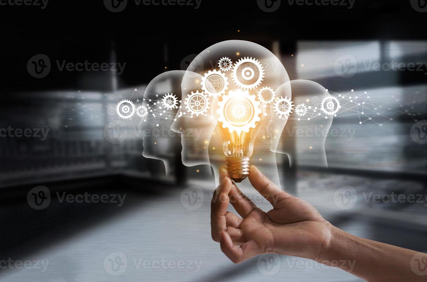 Hand holding light bulb and cog inside. Idea and imagination. Creative and inspiration. Innovation gears icon with network connection on human heads on metal texture background. photo