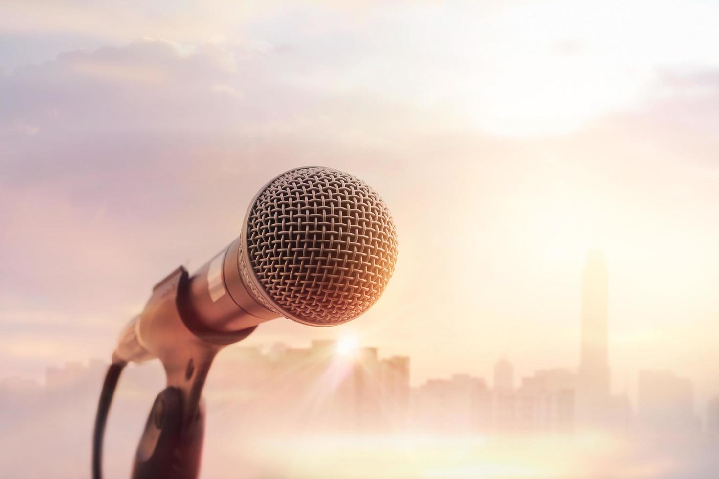 Microphone on stage on warming sunset city background photo
