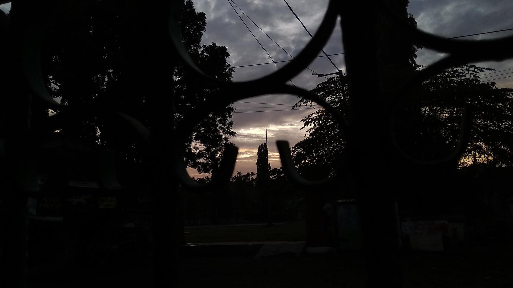 la vista de la mañana al amanecer vista desde detrás de la cerca de hierro foto