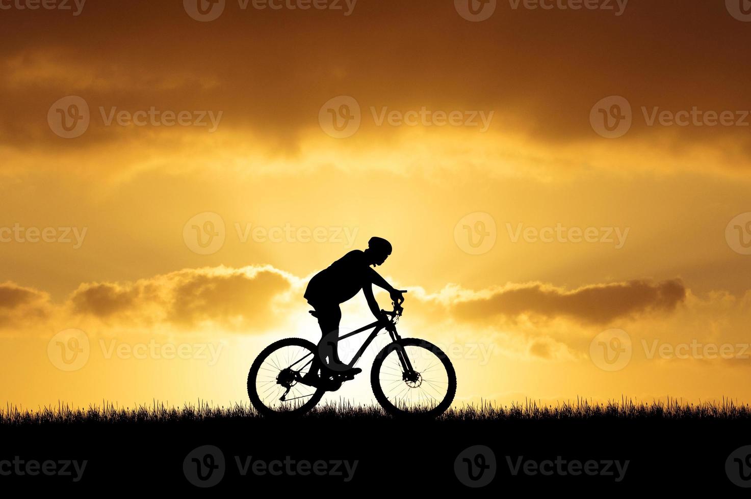 Silhouette of a cyclist in a beautiful evening meadow. bike vacation ideas photo