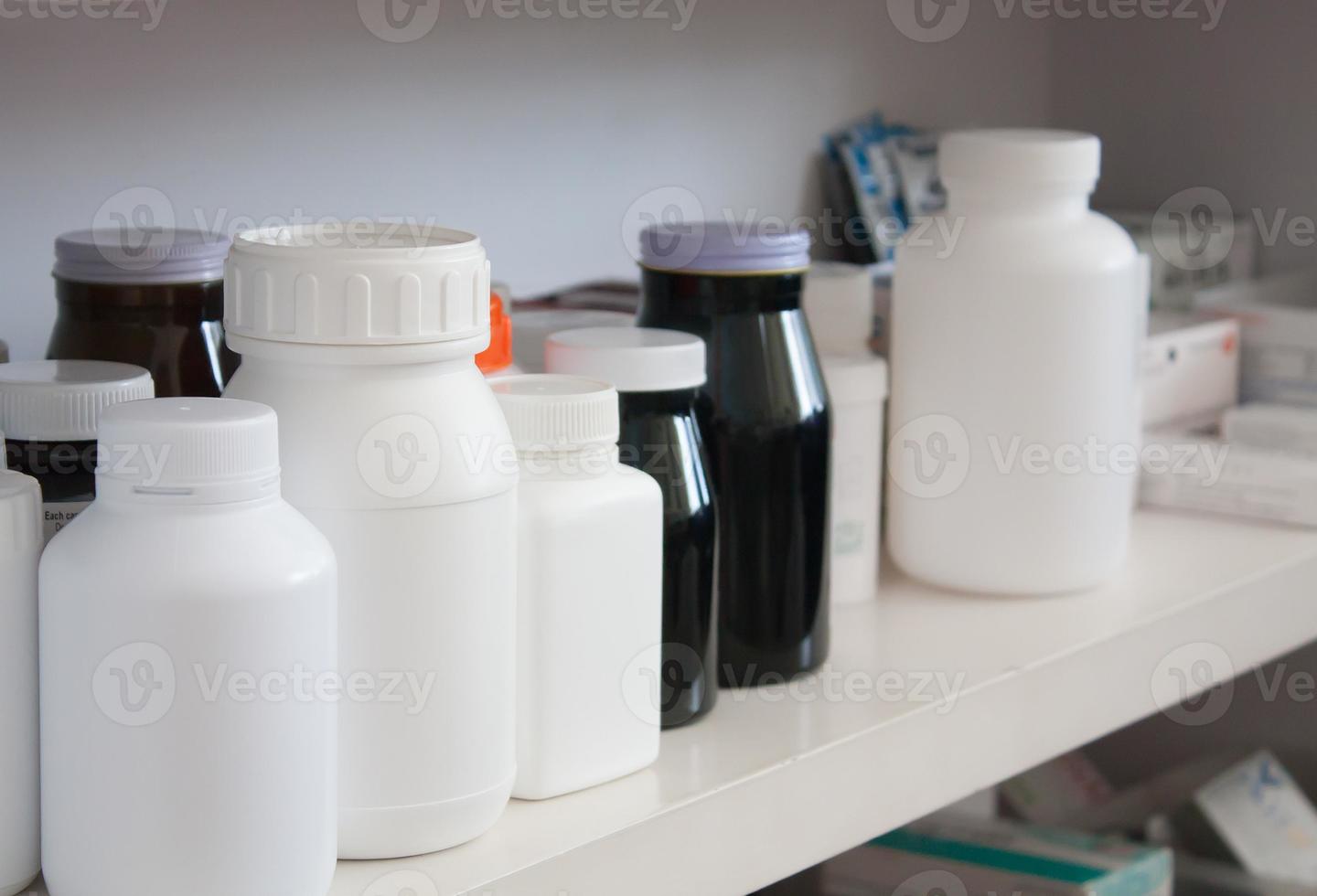 Bottles of pills arranged on shelf at drugstore photo
