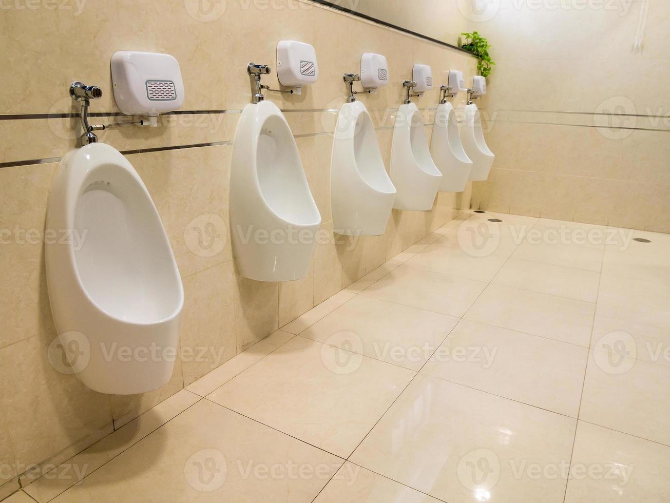 Closeup of white urinals for men in toilet room photo