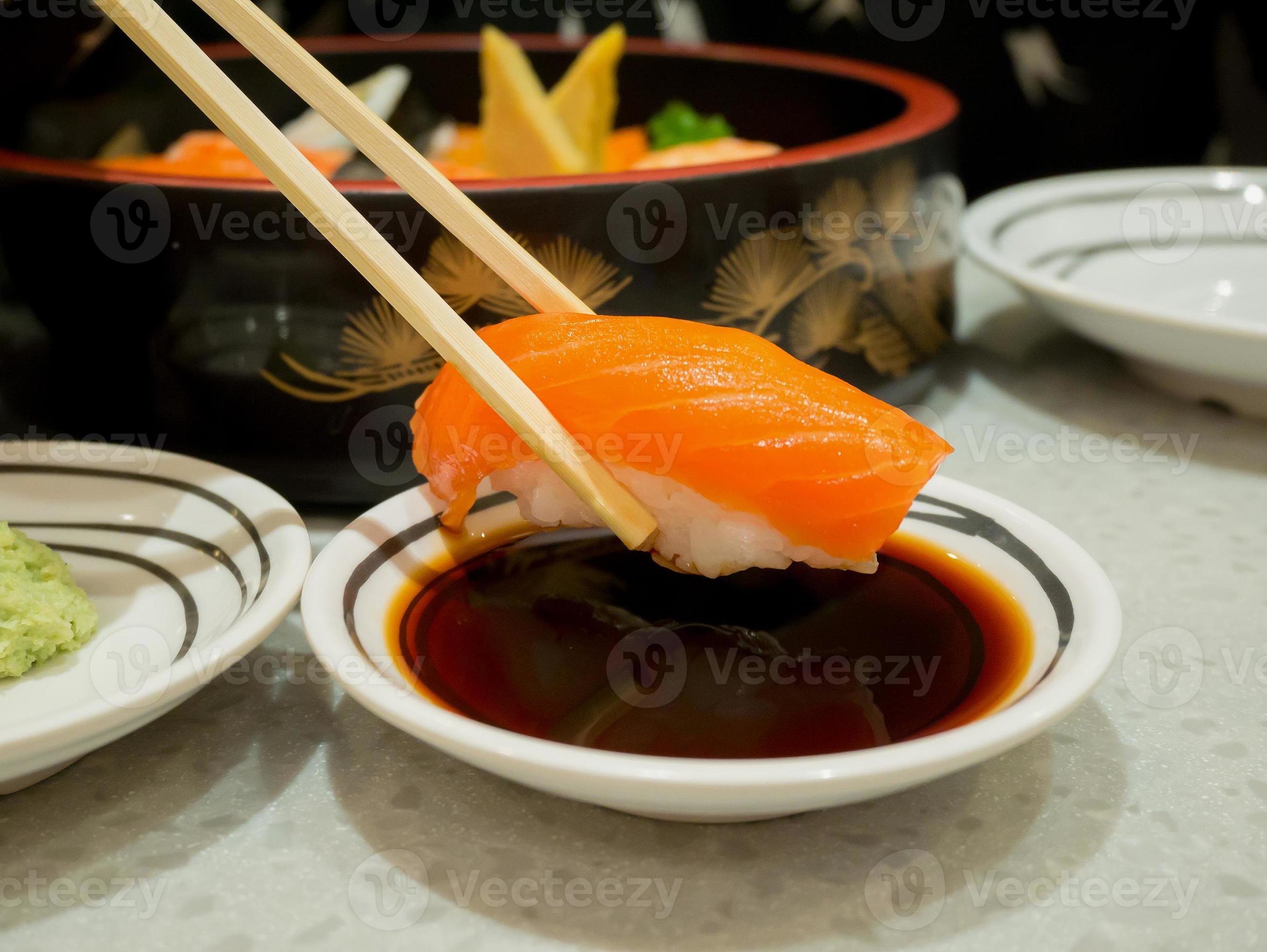 Salmon sushi in chopsticks dipping with soy sauce 6967792 Stock Photo