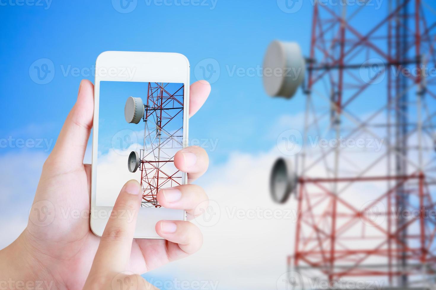 hand hold mobile smartphone with telecommunication tower photo