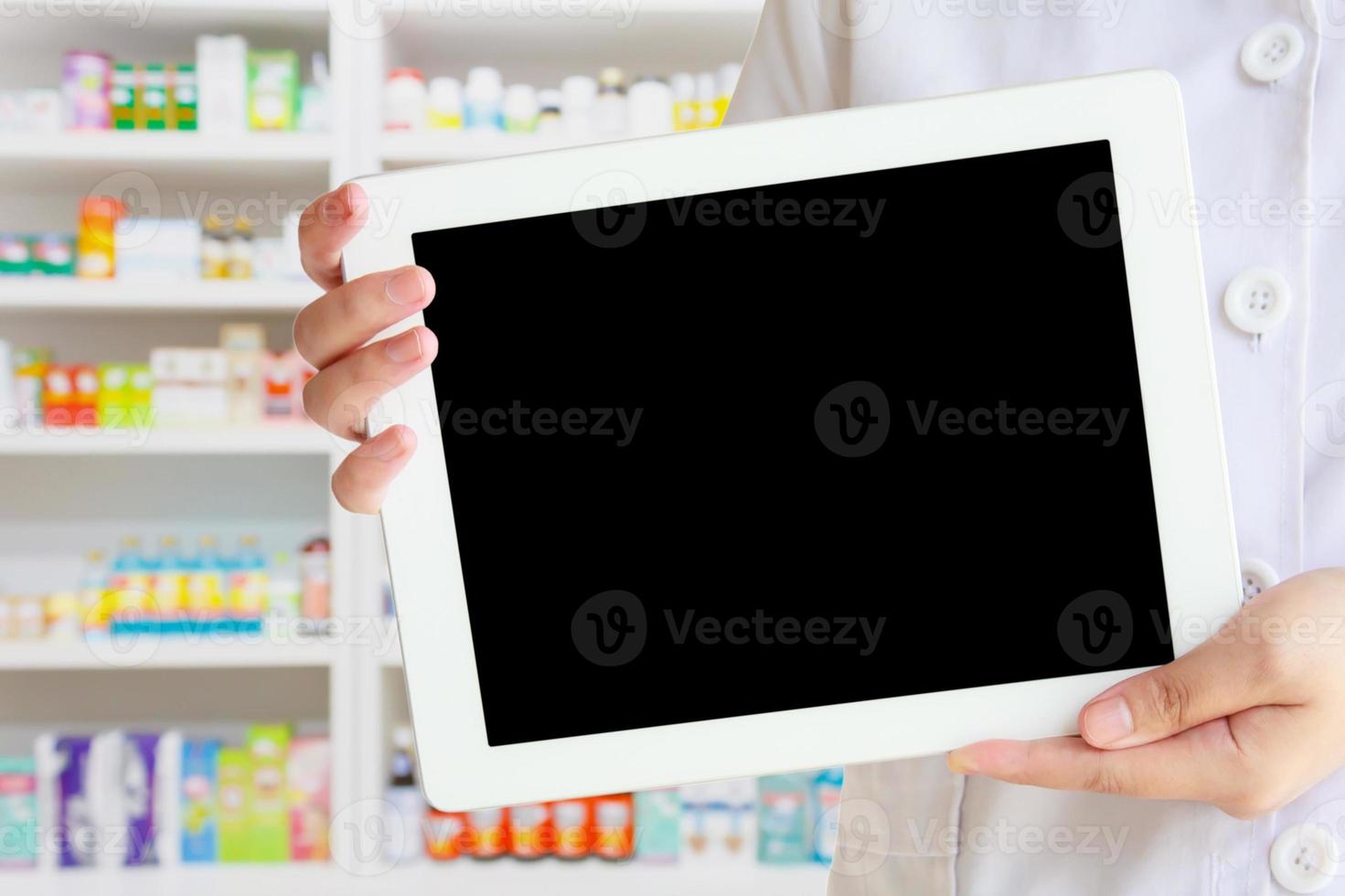 pharmacist showing tablet computer in the pharmacy photo