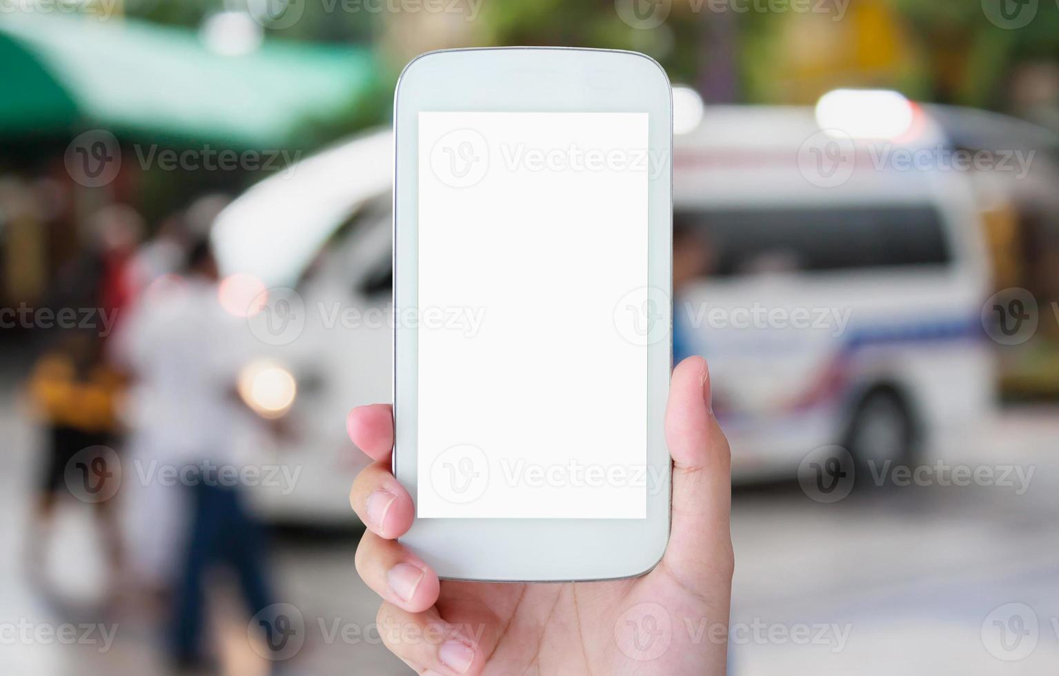 hand hold smartphone with Ambulance responding to emergency call photo