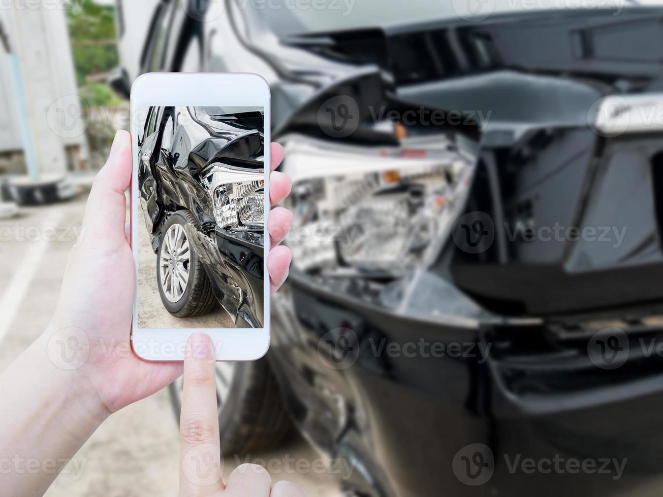 Hembra sostenga teléfono inteligente móvil fotografiando accidente automovilístico foto