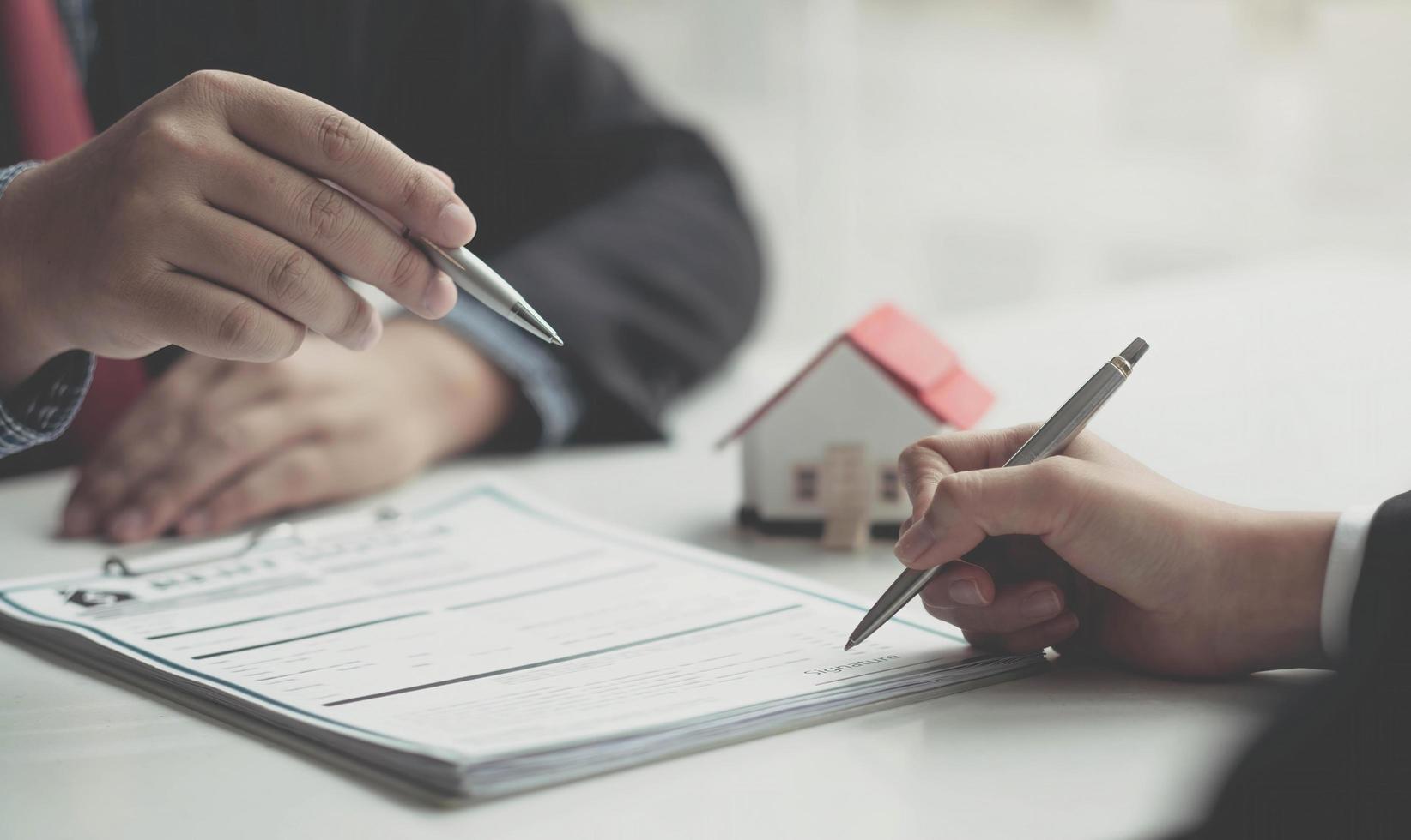 agente inmobiliario o gerente de ventas ha propuesto términos y condiciones a los clientes que firman contratos de compra de vivienda con seguro, acuerdo para firmar el concepto de contrato de compra. foto