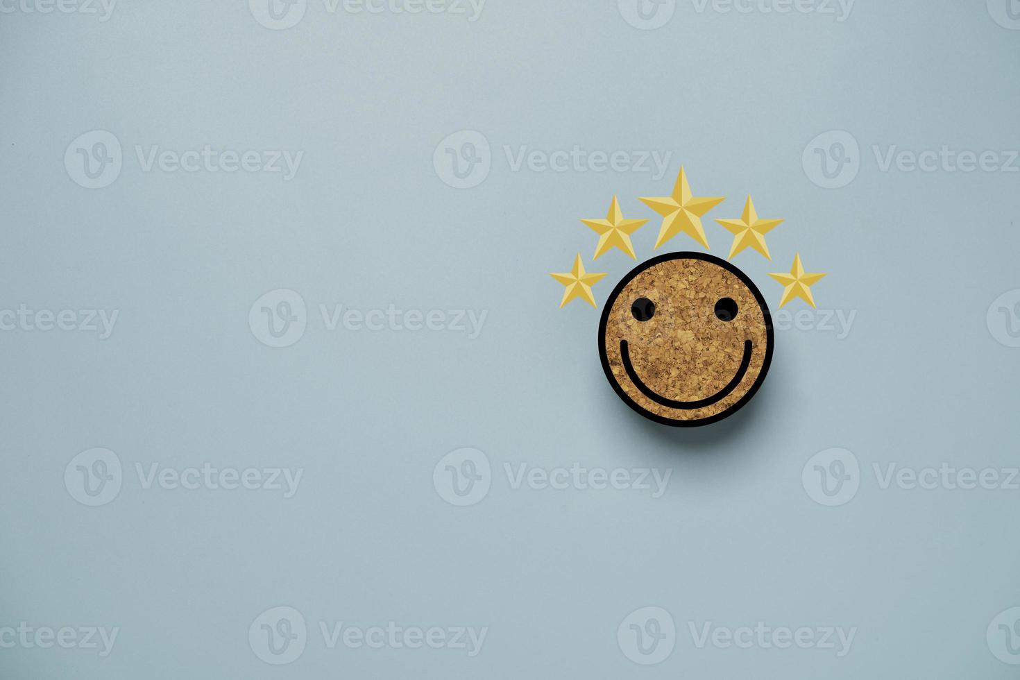 Smile face and yellow five stars print screen on circle wooden block for positive mindset and customer evaluation concept. photo