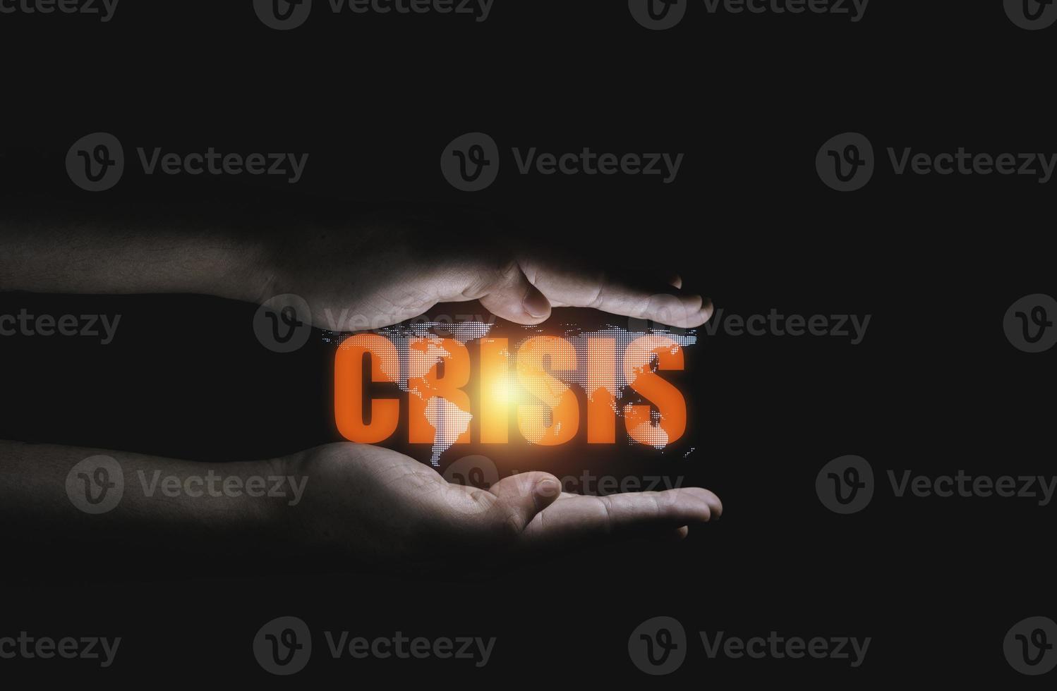 Crisis wording and world map between two hand on dark background for economic depression after covid-19 concept. photo